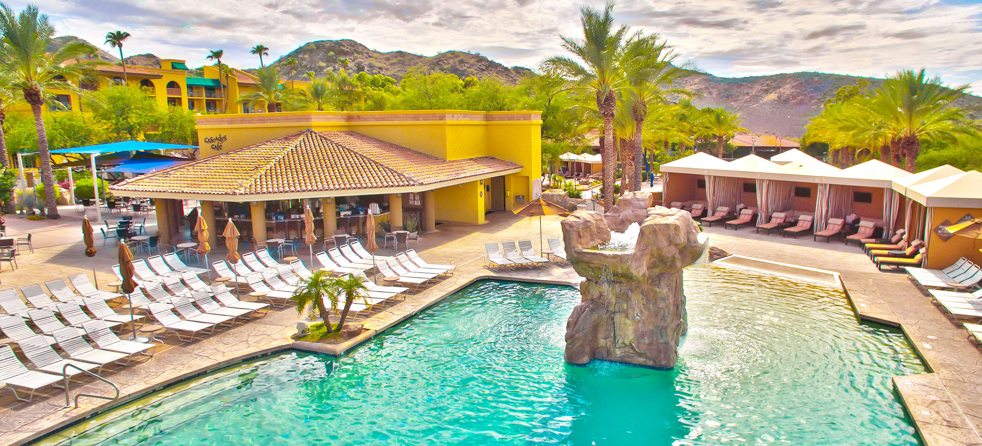 Cascades Cafe-hero-0 Photo of The Falls Water Village featuring the bar, lounge chairs, sparkling pool, cabanas, palm trees and surrounding mountains