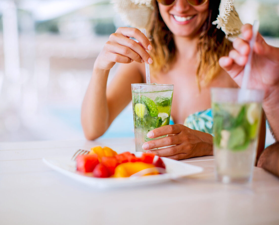 Couple drinking mojito in swimming pool bar Couple drinking poolside cocktails