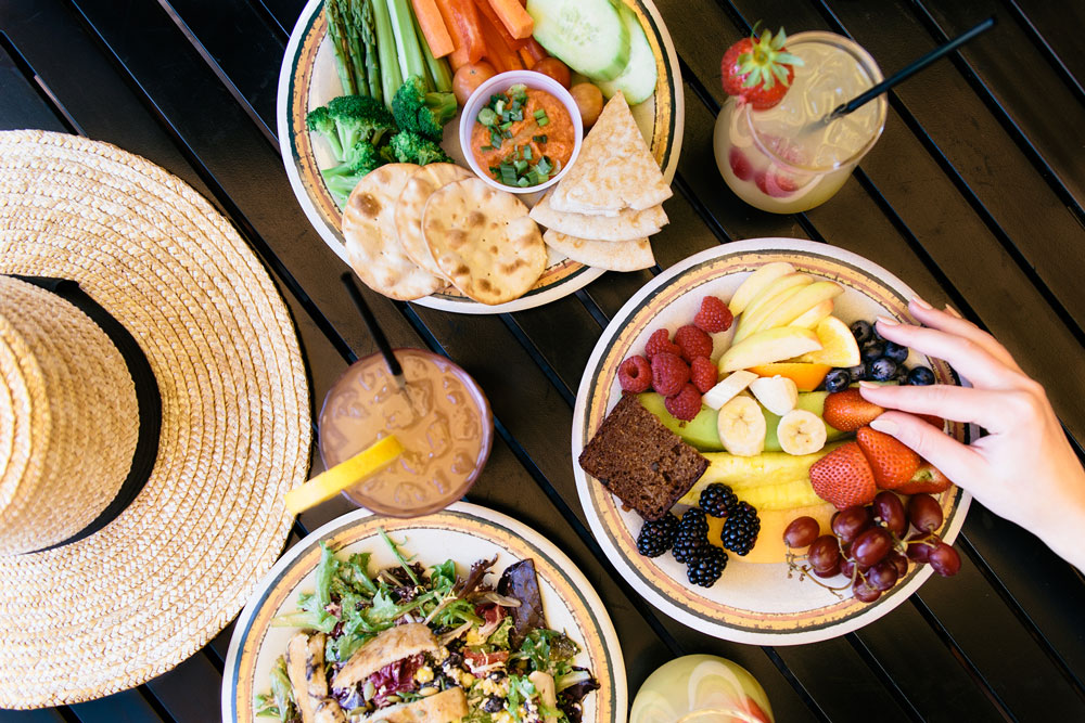 Photo of two refreshing cocktails and veggie and fruit plates