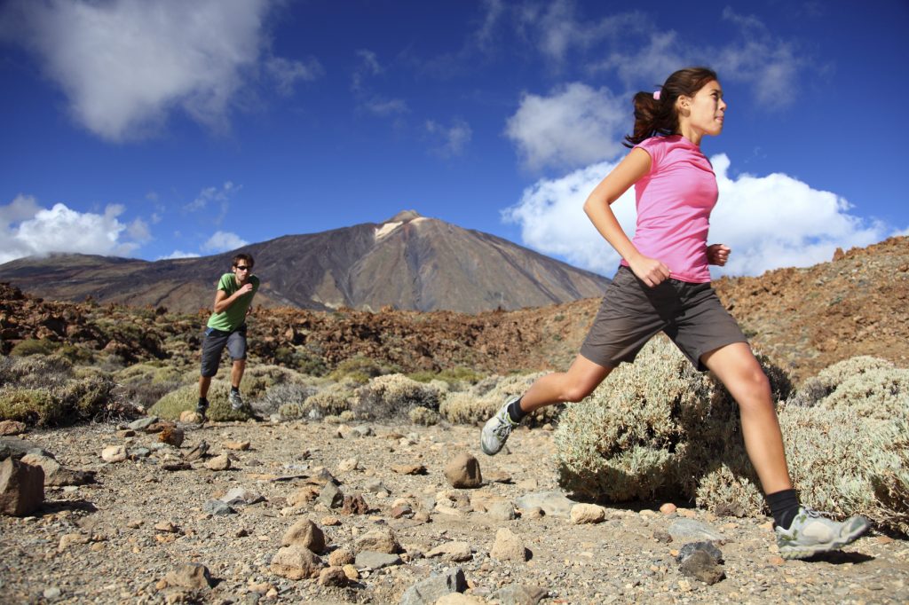 Man and woman running on a desert trail