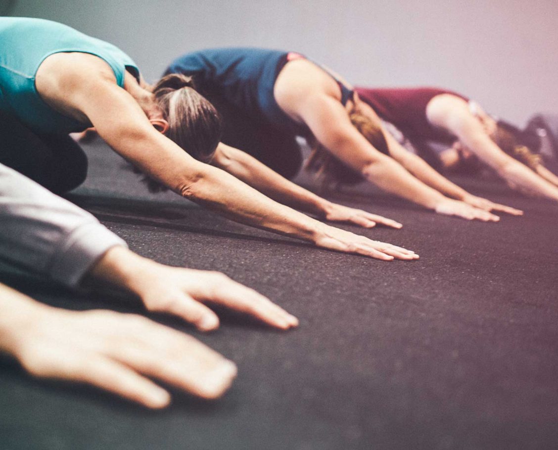 Group of men and women in a fitness stretch class