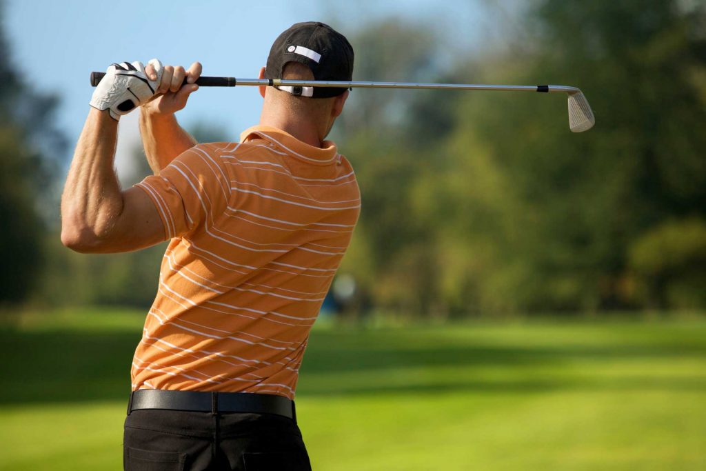 Golfer swinging his club on the fairway