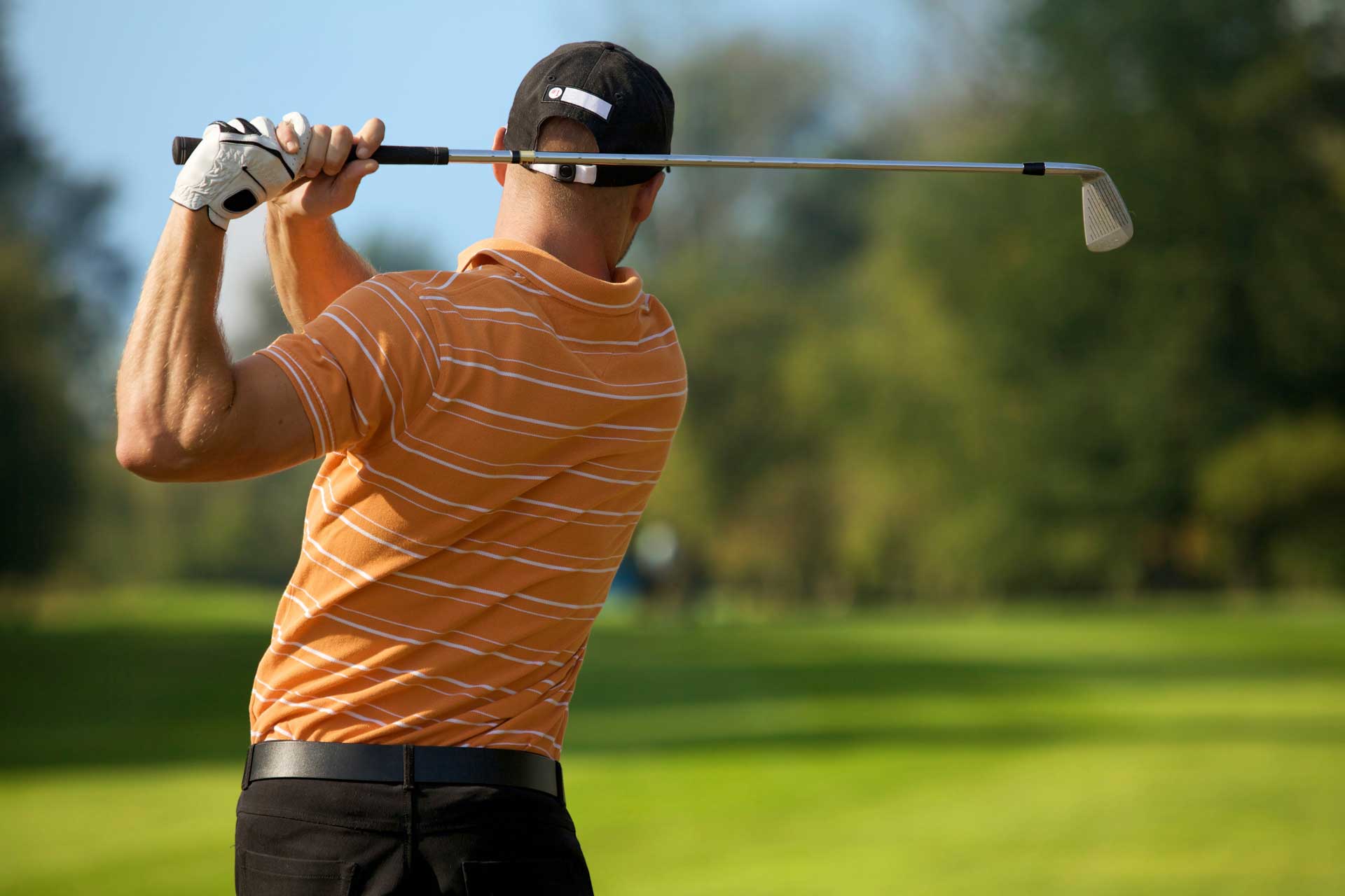Golfer swinging his club on the fairway