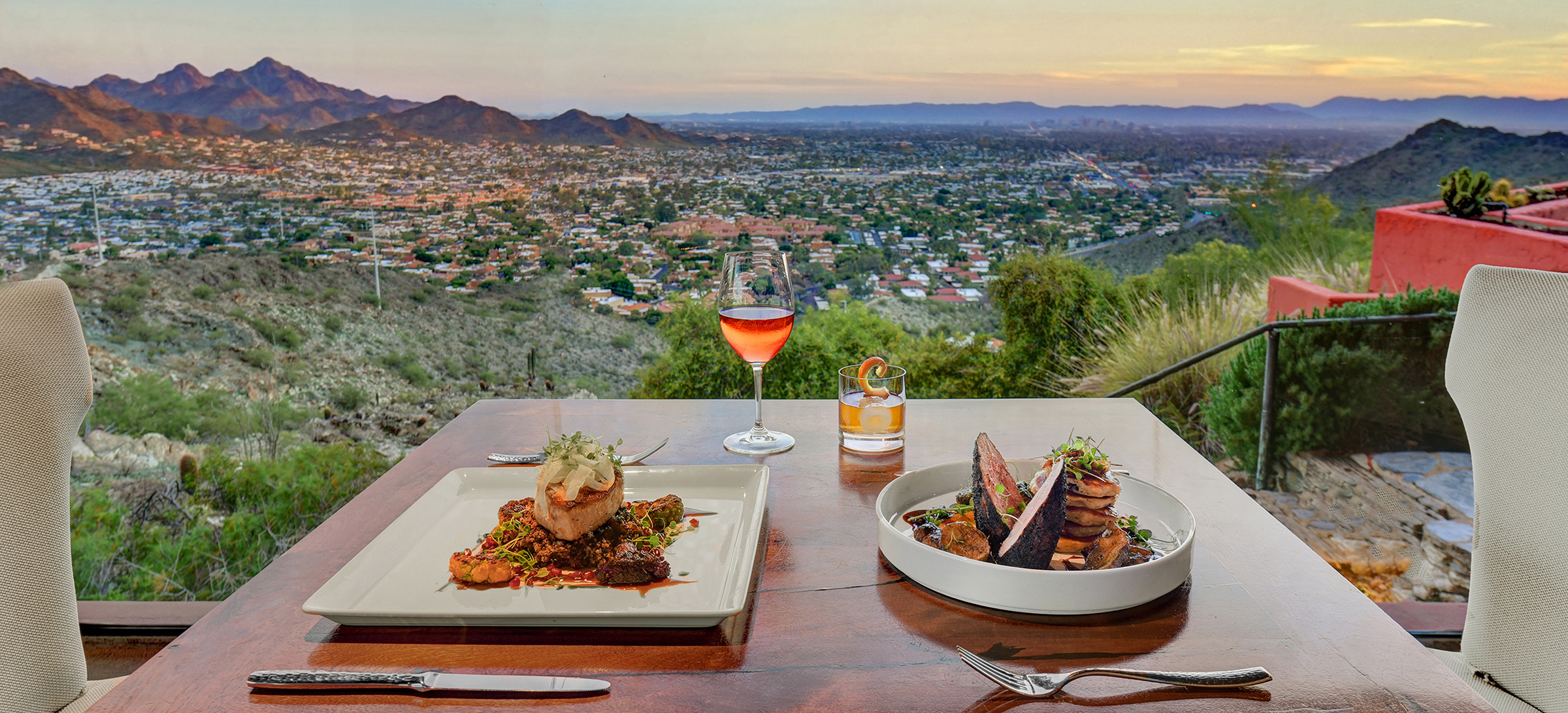 Dinner table set for two, overlooking valley views and mountain peaks at sunset time