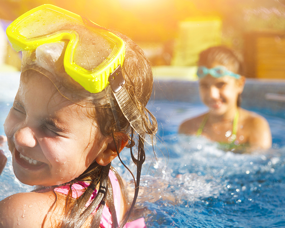 Children playing in pool. Two little girls having fun in the pool. Summer holidays and vacation concept